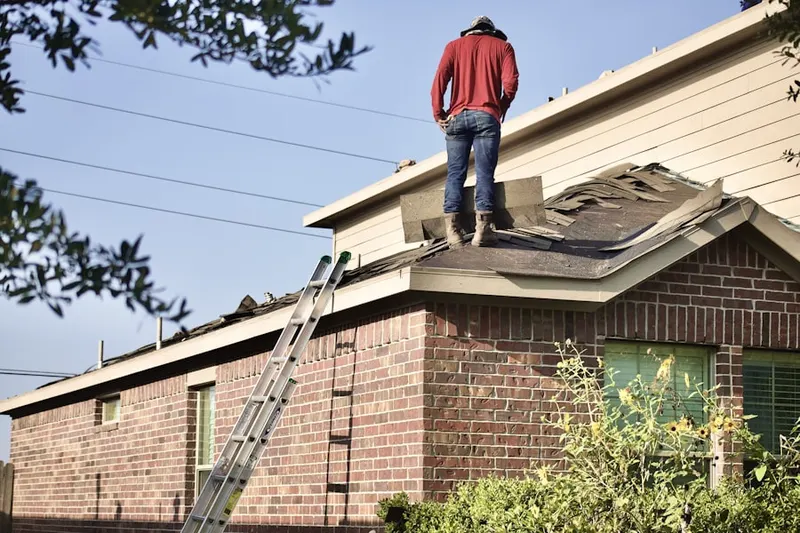 Professional roofer working on a residential roof in New England Heights